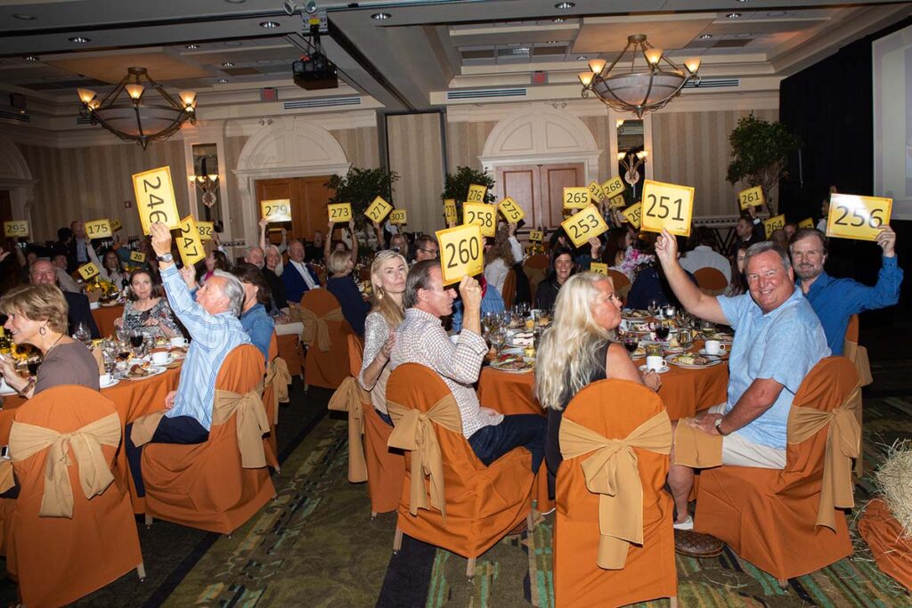 Group of people bidding on items at an auction.